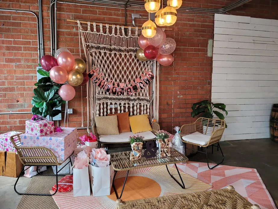 Bridal shower lounge corner at Brick + Laurel with a macramé backdrop and rattan seating